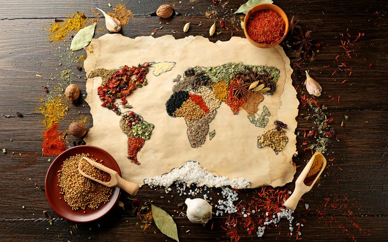 Map of world made from different kinds of spices on wooden background