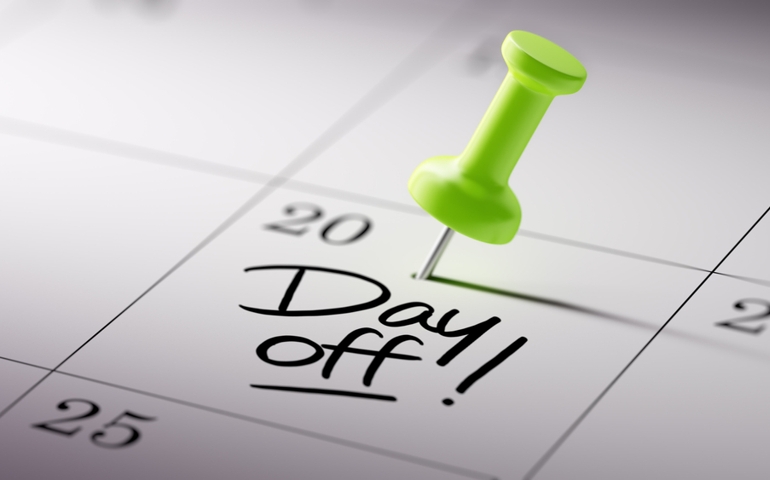 Concept image of a Calendar with a green push pin. Closeup shot of a thumbtack attached. The words Day off written on a white notebook to remind you an important appointment.