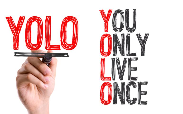 Hand with marker writing the word You Only Live Once