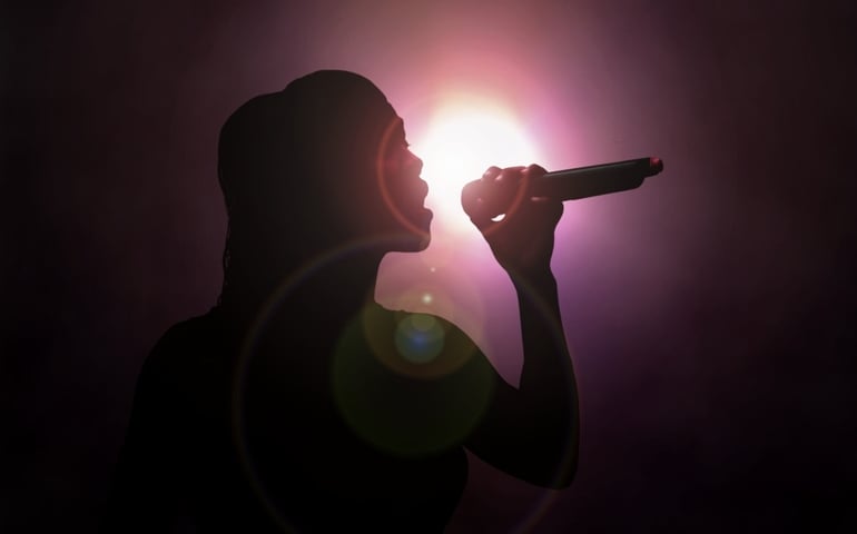 Women singing under spotlight