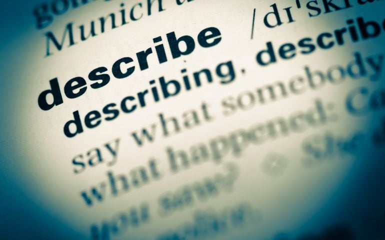 Close up of old English dictionary page with word describe