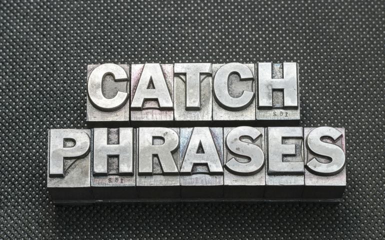 catch phrases made from metallic letterpress blocks on black perforated surface