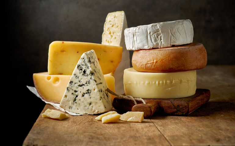 various types of cheese on rustic wooden table