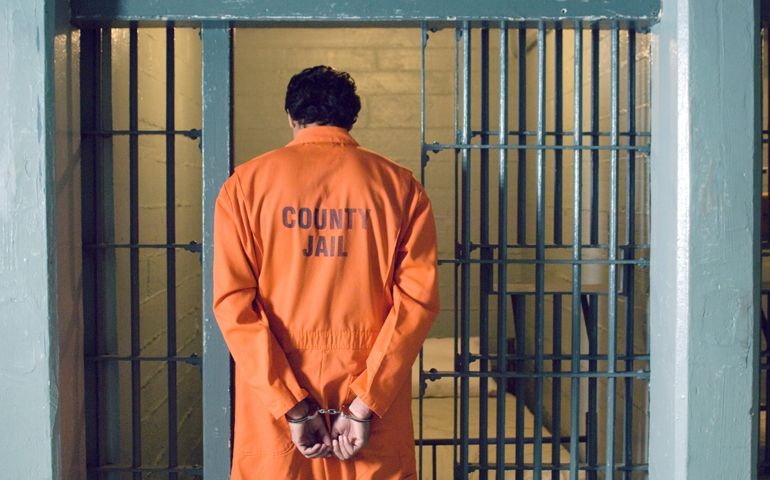 Handcuffed prisoner in jail