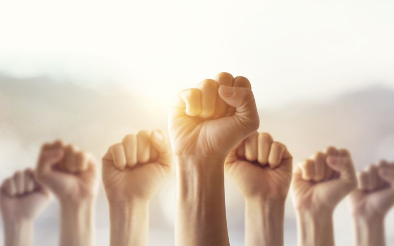 People raised fist air fighting for their rights with sunlight effect, labor movement, election movement, copy space