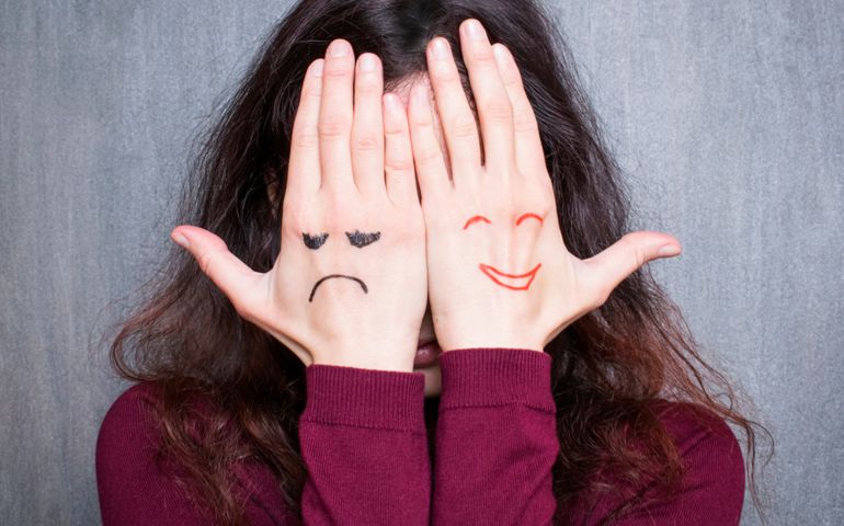 Different states of mood, woman covering her face with hands with drawn happy and sad
