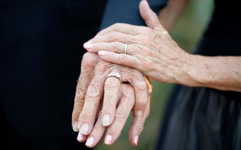 Older couple displaying their wedding rings after getting married. Their hands show the beauty of time, and set forth the idea that you are never too old for love or marriage.