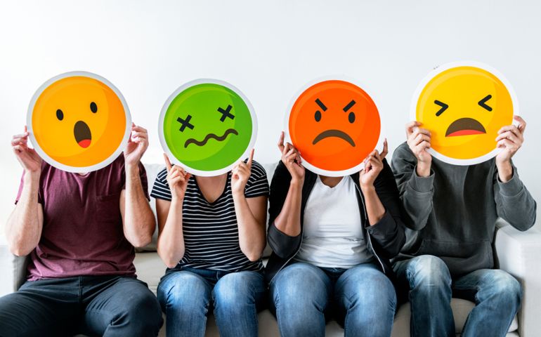 Diverse people holding emoticon
