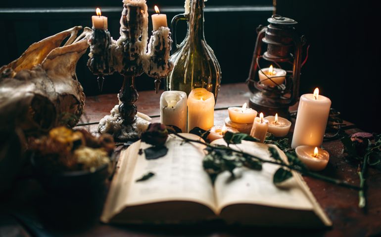 Witchcraft, dark magic, candles with ritual book