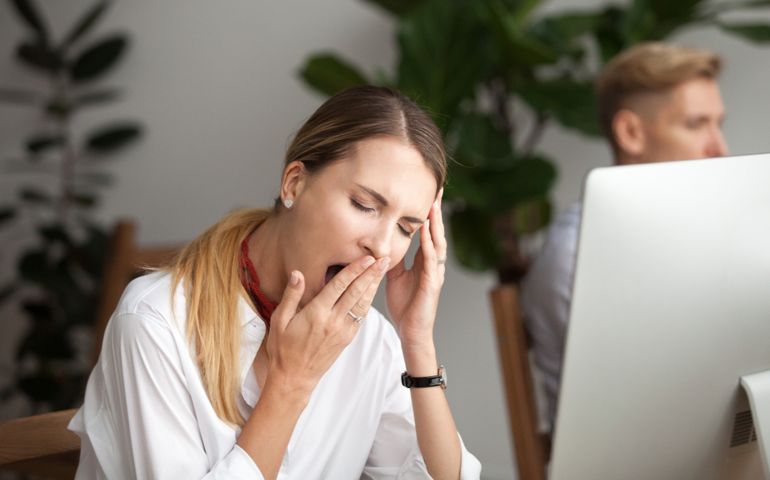 Bored businesswoman yawning at workplace feeling no motivation or lack of sleep tired of boring office routine, exhausted restless employee gaping suffering from chronic fatigue or overwork concept