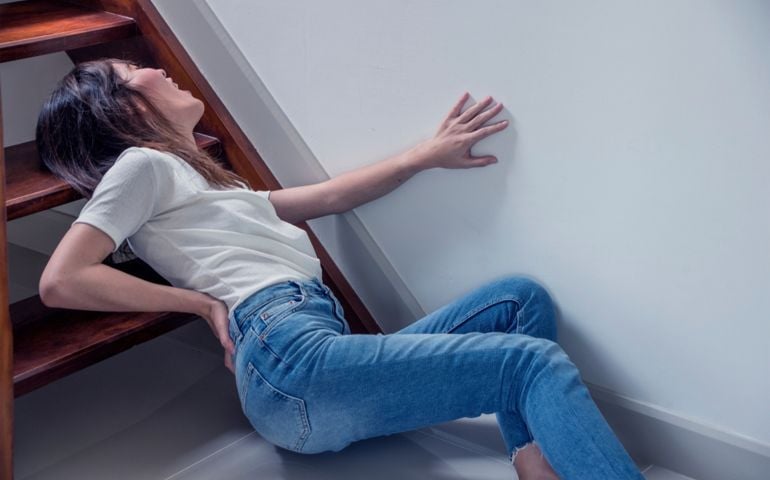 Attractive asian woman accident fall off the stairs and backache Pain or broken backache in home health insurance concept