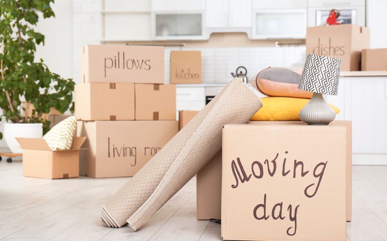Moving boxes and household stuff in kitchen.