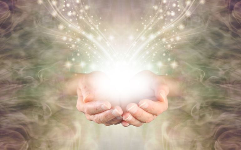 Sending You High Resonance Healing Energy - female cupped hands emerging from a green gold swirling energy field background with shimmering sparkles and white light flowing outwards