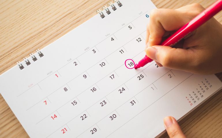 Hand with pen mark on calendar date
