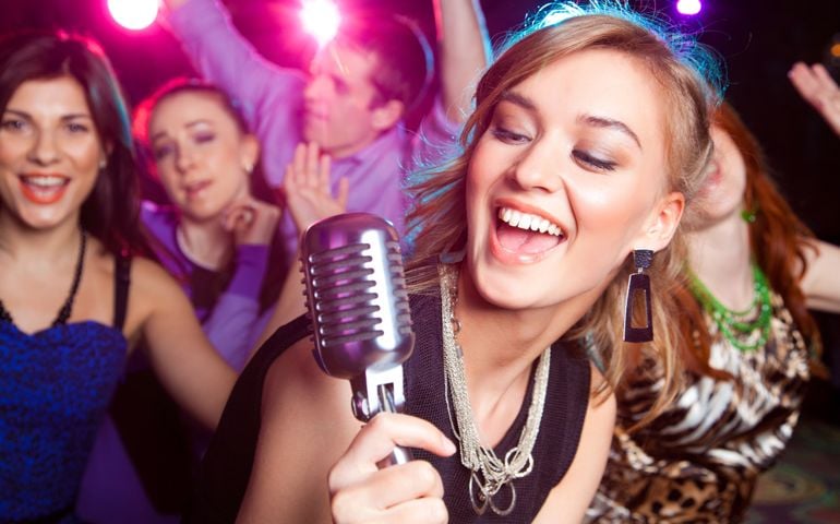 young girl singing into microphone at party