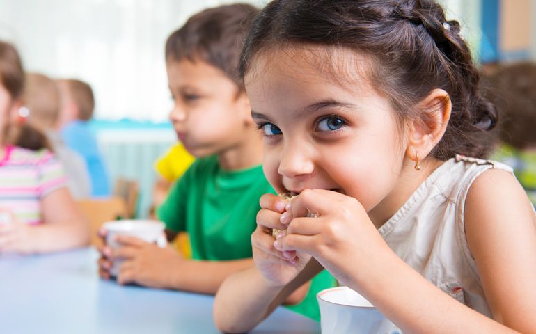 Cute little children drinking milk at daycare