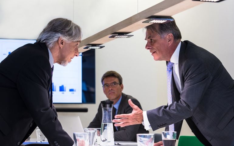Conflict in office : Business executive arguing with his boss at meeting over latest sales figures with others watching