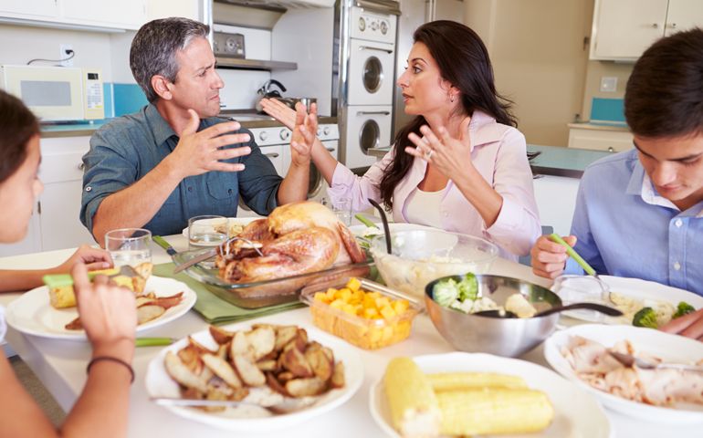 Family Having Argument Sitting Around Table Eating Meal