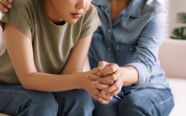 Middle aged asia people old mom holding hands trust comfort help young woman talk crying stress relief at home.