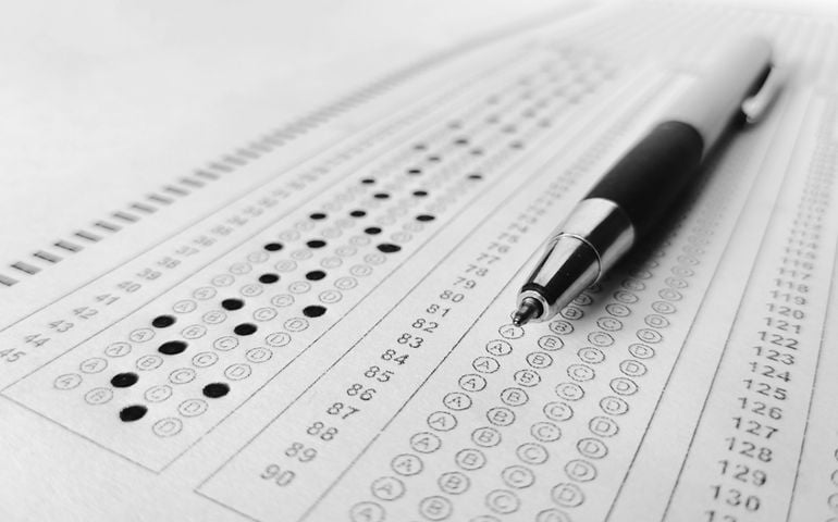 Man is filling OMR sheet handing with pen