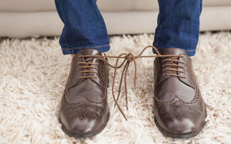 Classy mans shoelaces tied together at home in the living room