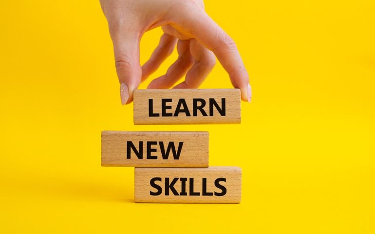 Concept words 'Learn new skills' on wooden blocks.