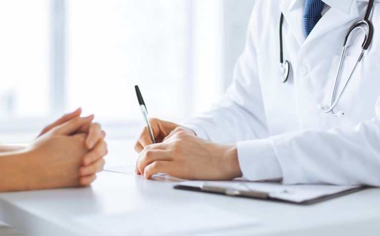 close up of patient and doctor taking notes