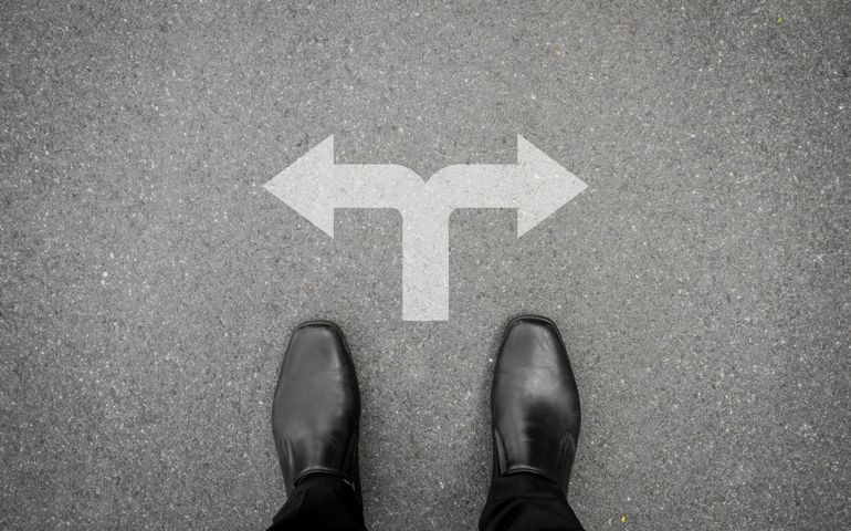 Businessman in black shoes making decision at the cross road