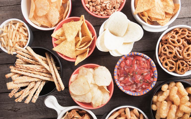 Salty crackers, tortilla chips and other savory snacks with salsa dip