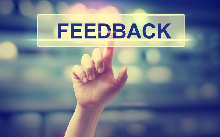 Feedback concept with hand pressing a button on blurred abstract background