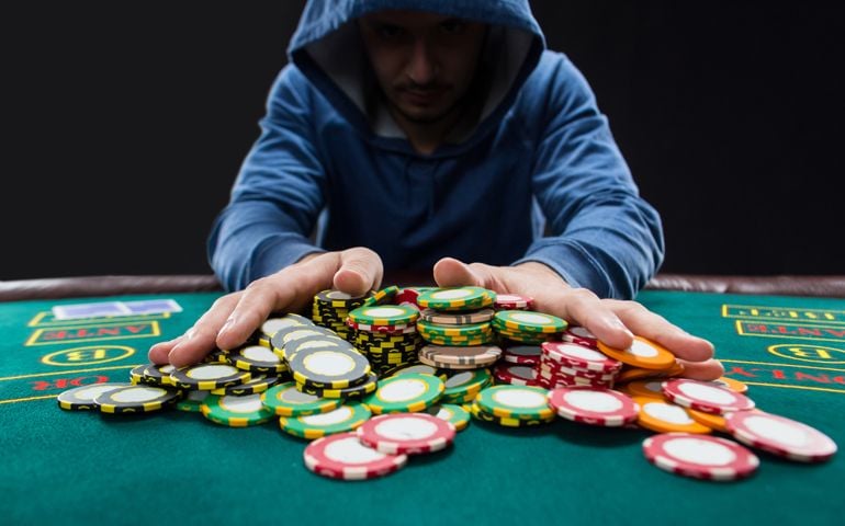 Poker player going all-in pushing his chips forward