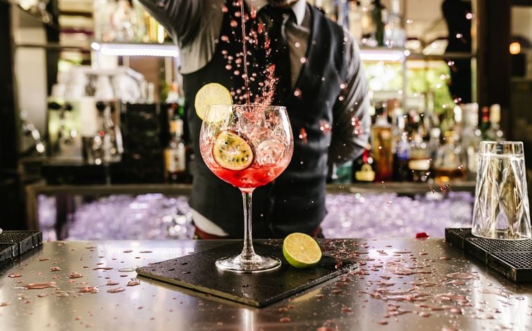Expert barman is making cocktail at night club.