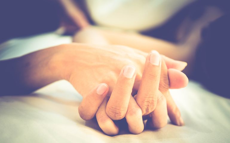 Hands of couple lovers having sex on a bed in morning with lust and love