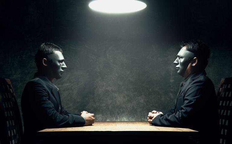 Man with a dark mask being agreed to keep their business