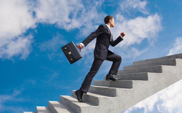Image of confident businessman with briefcase walking upstairs