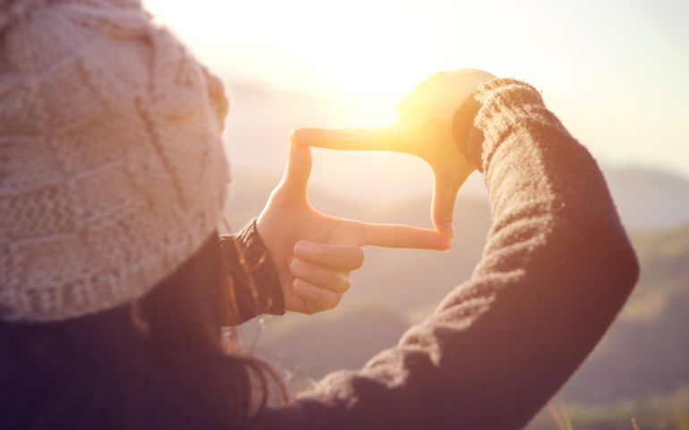 Future planning, Close up of woman hands making frame gesture with sunrise on mountain, Female capturing the sunrise, sunlight outdoor.