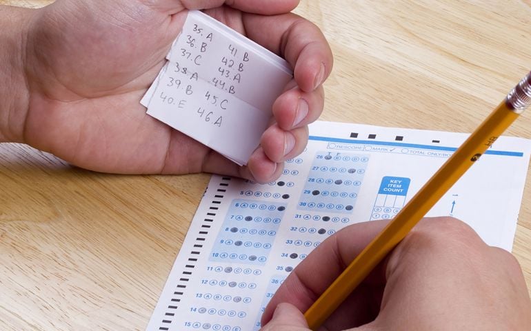Student using a cheat sheet to cheat on his test.