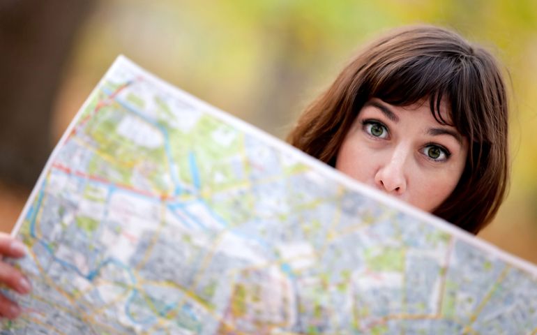 Lost woman in the countryside holding a map