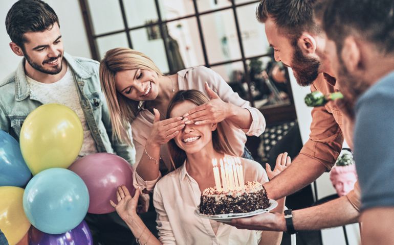 Surprise for her. Group of happy people celebrating birthday among friends and smiling while having a party