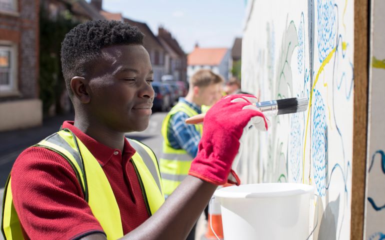 Group Of Helpful Teenagers Creating And Maintaining Community Art Project