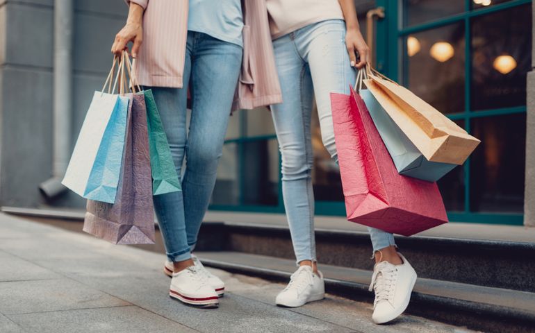 Look what we got. Cropped portrait of young lady and her mother holding colorful shopping bags