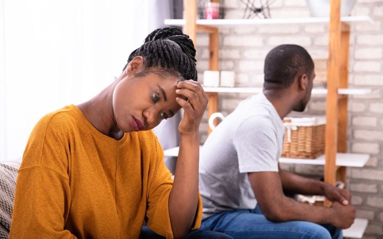 Upset Young African Couple Sitting On Sofa Ignoring Each Other