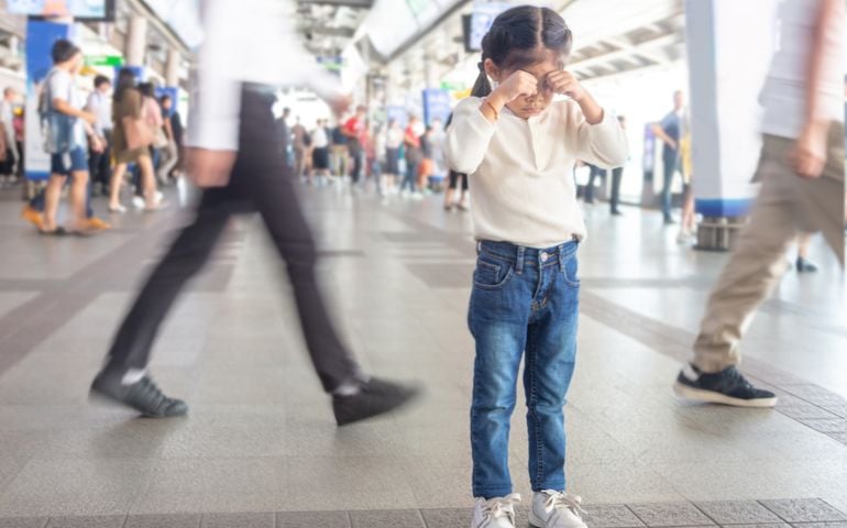 asian kid crying to lost parent or live alone on sky train station in Bangkok city,Thailand