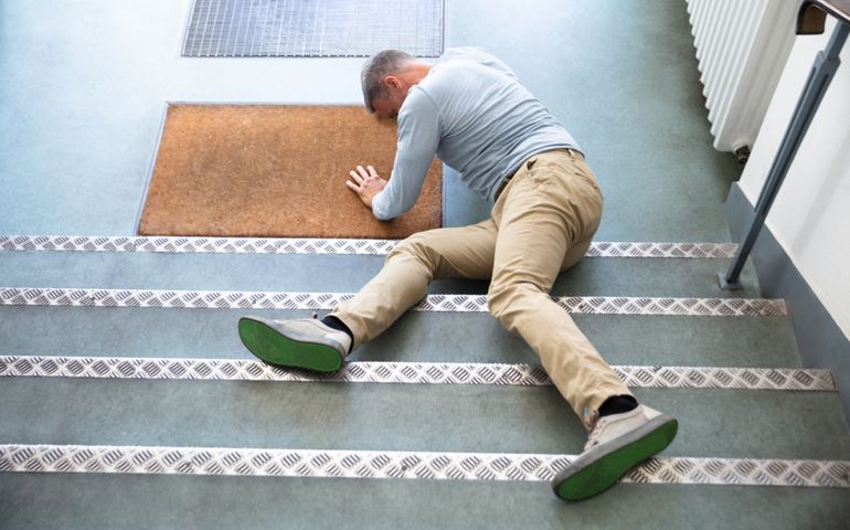 Mature Man Lying On Staircase After Slip And Fall Accident