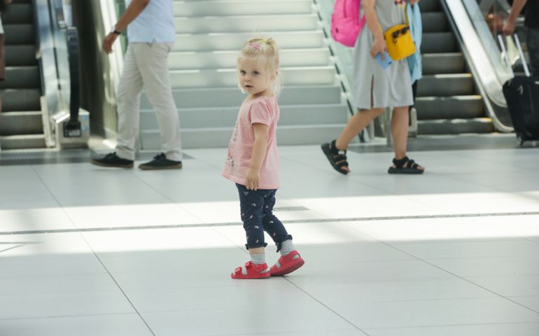 Child lost at the airport or shopping mall, little girl looking for her parents
