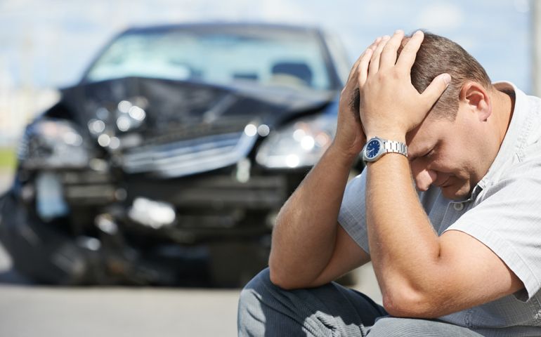 Adult upset driver man in front of automobile crash car collision accident in city road
