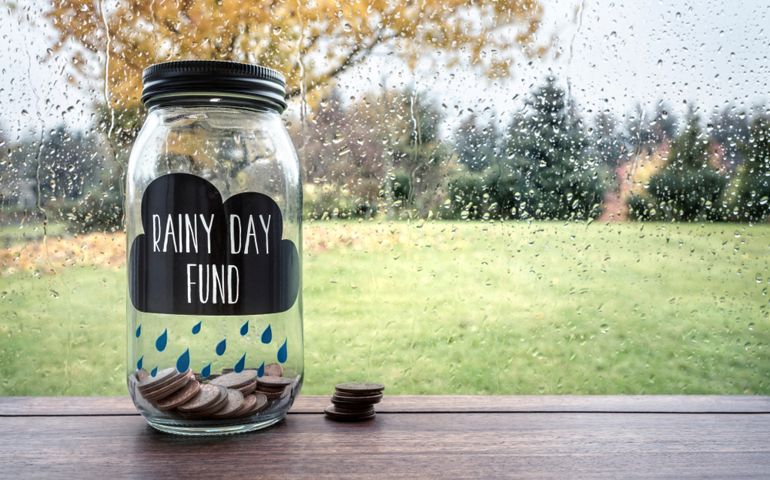 Savings for a rainy day fund glass jar with money