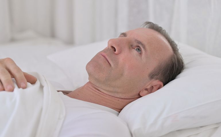 Pensive Middle Aged Man Awake in Bed Thinking