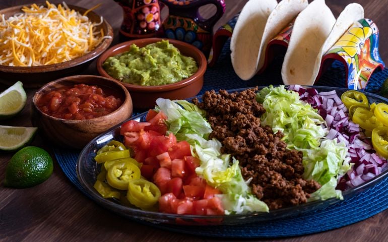 Close up of a platter filled with toppings for making tacos.