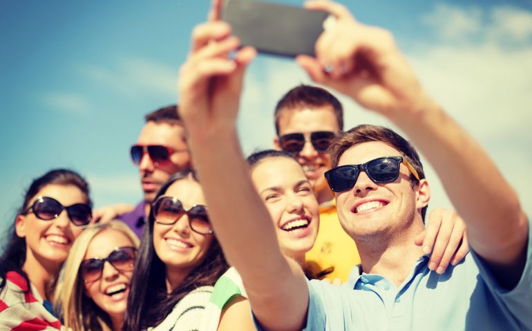 summer, holidays, vacation and happiness concept - group of friends taking selfie with smartphone
